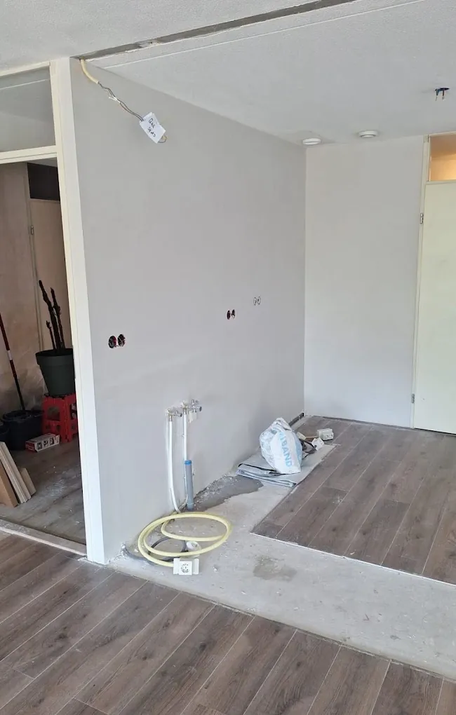 Woning tijdens de verbouwing, met leidingwerk in de wand